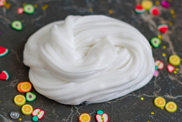close up homemade toy white butter slime and accessories for decoration