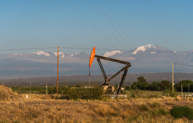 Oil pump jack at the background of Andes mountains