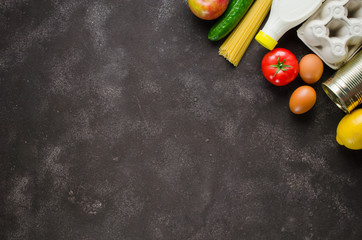 Various groceries on dark concrete background. Food delivery concept. Food donations.