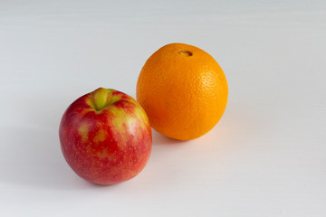 Juicy apple and orange on a white background. vitamin juice