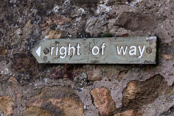Wooden Right of Way sign on stone wall