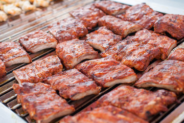 Outdoor picnic scene of bbq with delicious spare ribs on a grill 