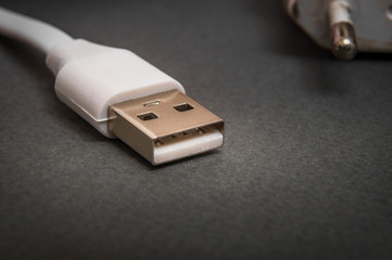 USB charger cable on black surface closeup often used for charging smartphone or tablet