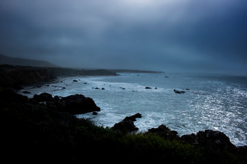 Moody Sunrise Under Fog with Breaking Surf in California