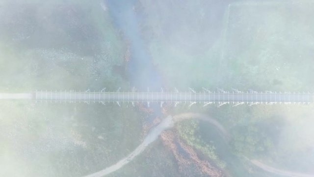 moody sunrise top down fog to reveal historic bridge opening scene