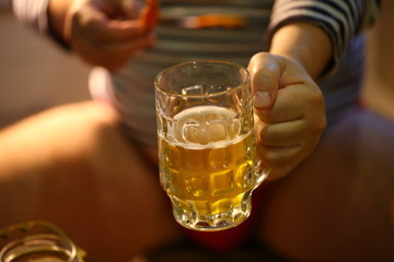 A man drinks beer and eats crayfish