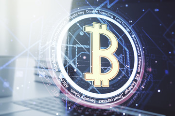 Double exposure of creative Bitcoin symbol with modern laptop on background. Cryptocurrency concept