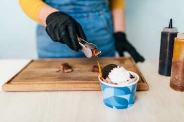 Close up shot of female worker's hands working in handmade ice cream store.