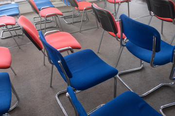 Empty chairs red and blue in auditorium or room. Vacant seats. No people.