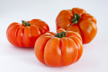 Fresh Italian pisanello tomatoes on white background. Close-up image with selective focus.
