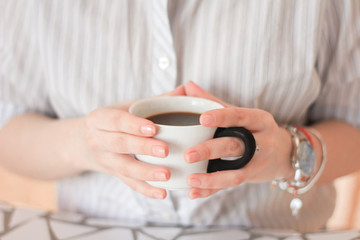 Female hands holding a cup of coffee