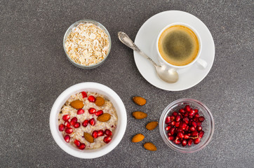 Healthy eating, breakfast. Oatmeal with pomegranate and nuts, black coffee.