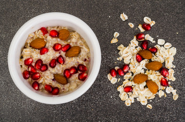 Healthy eating, breakfast. Oatmeal with pomegranate and nuts, black coffee.