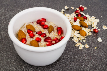 Healthy eating, breakfast. Oatmeal with pomegranate and nuts, black coffee.