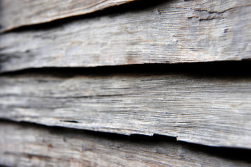 The wall is covered with old boards, gray from time, rain and wind.