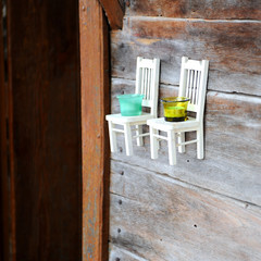 Small decorative chairs on the wall serve as candlesticks.