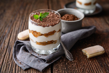 Classic Italian coffee no bake dessert, delicious easy Tiramisu in a jar, sprinkled with cocoa powder and chocolate shavings