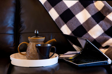 At home work time on sofa with tea and laptop