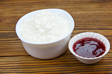 Tasty fresh grained cottage cheese on a plate on  wooden table