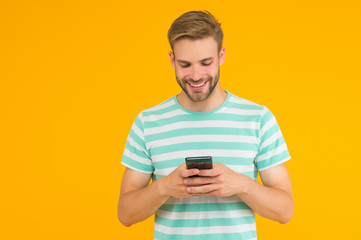 Texting SMS message. Happy guy send sms via smartphone yellow background. Sms messaging. Short message service. New technology. Mobile lifestyle. Modern life. Trusted SMS delivery