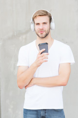 Takeaway beverage on the move. Handsome man listen to music drinking coffee. Young guy hold drinking cup outdoors. Healthy drinking habit. Drinking hot chocolate or tea. Music and diet. Modern life