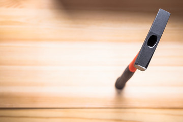 quality hammer on a wooden table. focus on the iron hammer, blurred background. space for text. copy space