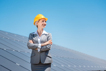 Woman investor in clean energy standing in front of solar panels