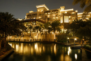 DUBAI, UAE -: Night view of Madinat Jumeirah hotel, Dubai, UAE. Madinat Jumeirah - luxury 5 star hotel with own artificial canals and boats.