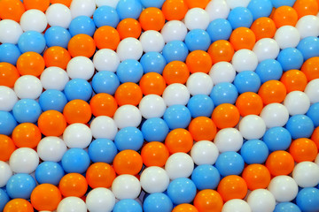 Garlands of balloons in orange, blue and white color as a background. Multi-colored balloons tied in rows for decoration