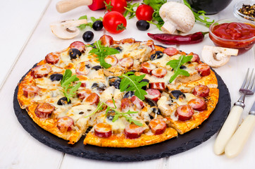 Tasty pizza with salami, mozzarella, mushrooms and olives on wooden background.