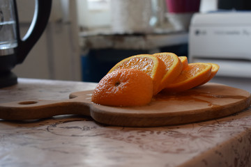 Slice of orange on cutting board close up on the table. Horizontal photo of an orange. Citrus on wooden board