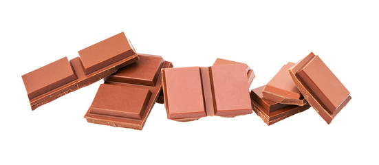 Milk chocolate pieces isolated on white background, close-up.