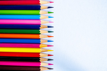Color pencils lay on a white background