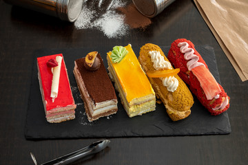 assorted cakes on black wooden table