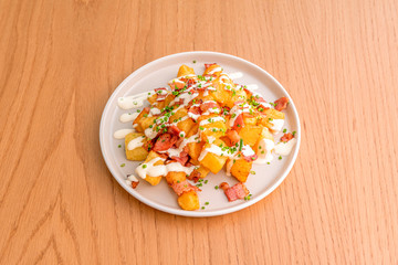 portion of patatas bravas on wooden table