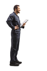 Male worker in a uniform holding a clipboard with a document