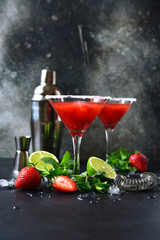 Cold summer strawberry cocktail with lime and mint ( mojito, margarita, rossini,daiquiri ) in a martini glasses.