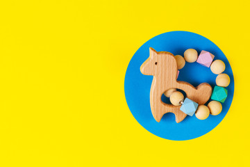 Baby kid educational natural eco zero waste wooden rattle toy on yellow and blue background