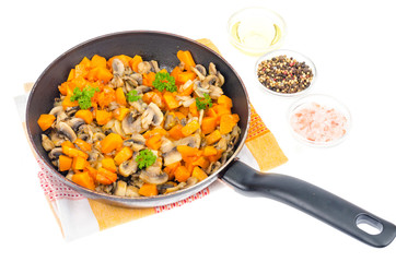 Vegetarian vegetable stew of pumpkin and mushrooms in pan, white background.