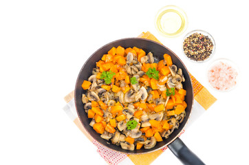 Vegetarian vegetable stew of pumpkin and mushrooms in pan, white background.