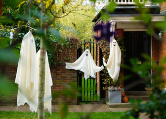 Halloween decorations of traditional english house. Cute ghosts made from sheets seem good and simple idea of decoration.  