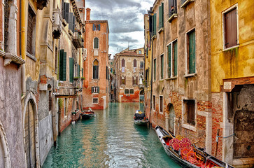 Fototapeta na wymiar Canal with boats in Venice (Italy) on a cloudy day in late autumn