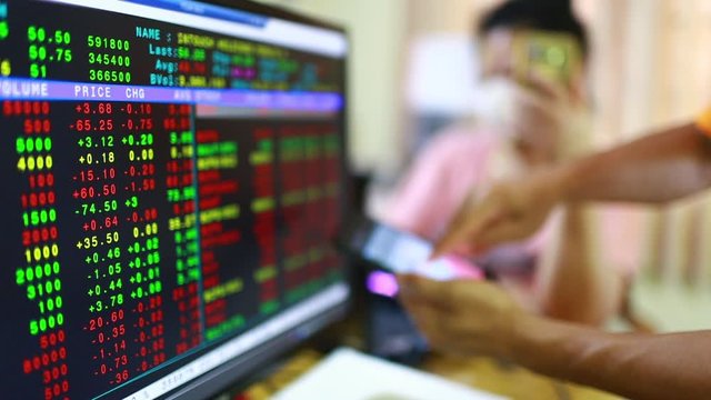 Stock exchange market business. Display of Stock market quotes with blurry red graph on smartphone and the patient is wearing a mask. The concepts of the economic downturn from Covid 19.