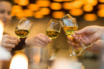 Clinking glasses with white wine and toasting.