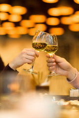 Clinking glasses with white wine and toasting.