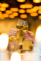 Clinking glasses with white wine and toasting.