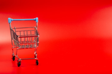 Empty Groceries trolley on red background