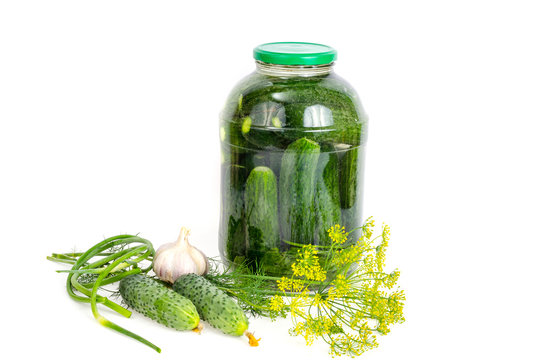 Glass jar with pickled cucumbers and herbs