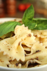 Farfalle pasta with fresh pesto serve in a white bowl