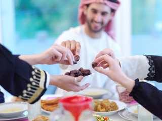 Muslim family having Iftar dinner eating dates to break feast
